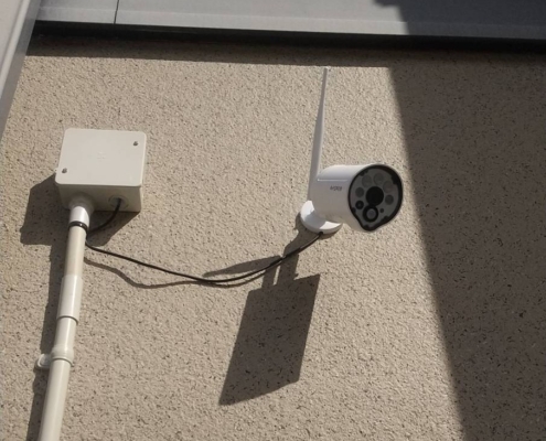 戸建て住宅の外壁に設置したカメラ付き防犯カメラと配線処理の様子